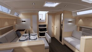 Un intérieur compact et bien éclairé, comprenant un coin repas, des sièges et des placards de rangement.
