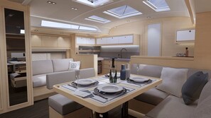 Un intérieur compact et bien éclairé, comprenant un coin repas, une kitchenette et un espace salon.