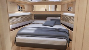 Un intérieur moderne avec un lit central, des étagères intégrées et une lucarne.