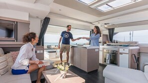A modern interior with a dining area, a kitchen, and a seating area with a view. - Caribbean Dream: Sun-soaked Sailing Adventure from Tortola, Islas Vírgenes Británicas (Road Town)