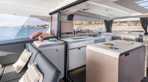 A yacht interior with a dining area, kitchen, and seating. - Caribbean Dream: Sun-soaked Sailing Adventure from Tortola, Islas Vírgenes Británicas (Road Town)