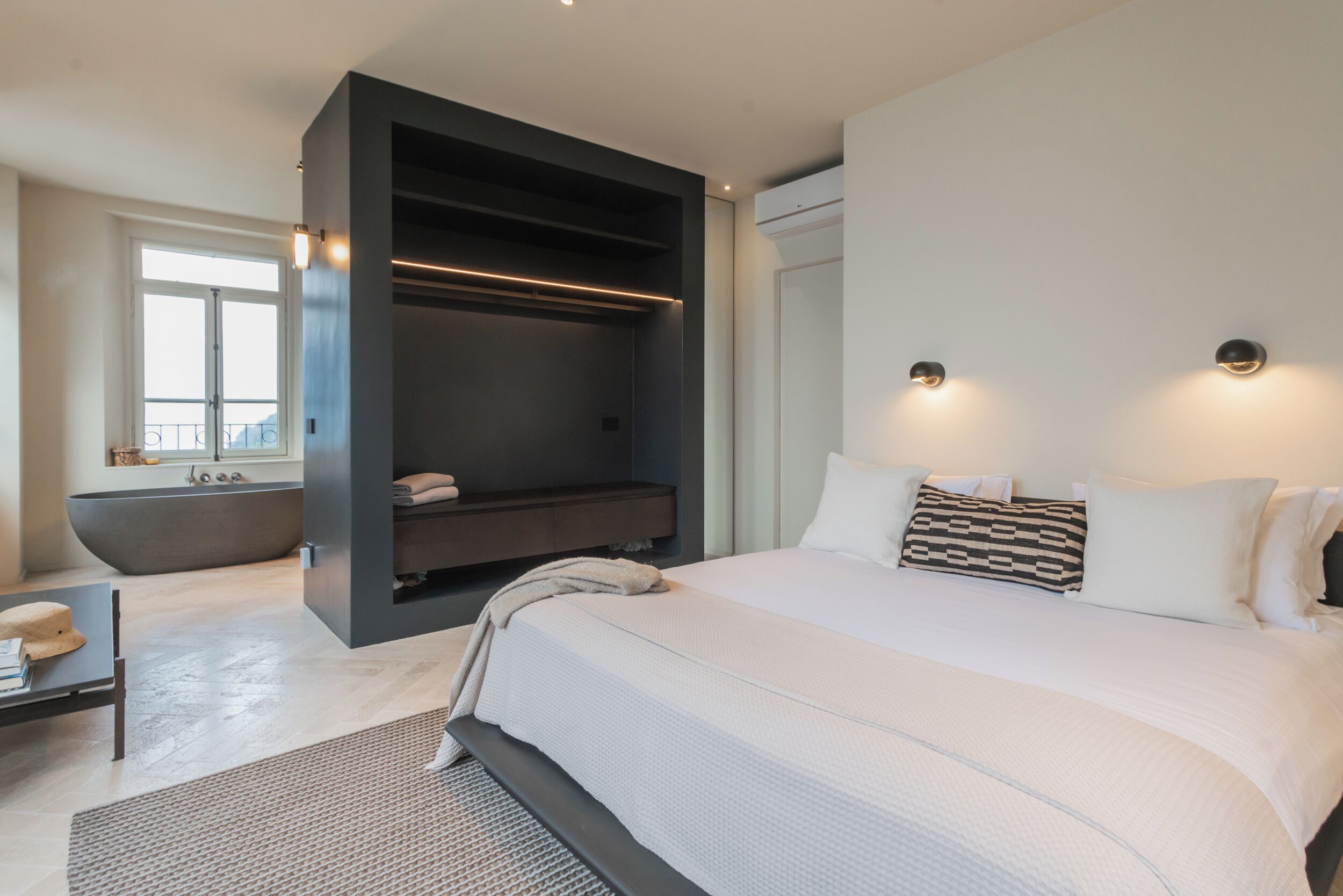 Une chambre à coucher moderne avec un grand lit, un placard intégré et une baignoire.