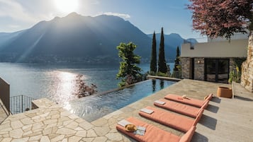 Una piscina al aire libre, sillones reclinables de piscina