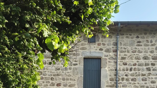 A stone building with a central arched entrance, two windows, and a small door. - Beautifully renovated family home (Saint-Romain)