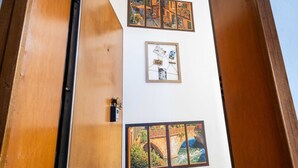 Eine Wand mit gerahmten Bildern, einer Tür und einer Holzkonstruktion.