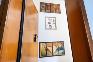 A wall with framed pictures, a door, and a wooden structure. - A practical 40 square meters studio apartment, perfect for three people, located on the fourth floor of a building without an elevator.The property is located in a centrally located area (limited traffic zone) of Modena, allowing our guests to explore th (Modena)