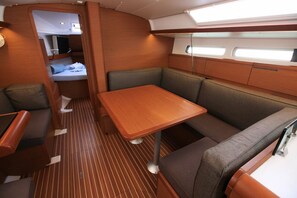 A compact, well-lit interior with a dining area, seating, and a small kitchenette. - Caribbean Dream: Sun-soaked Sailing Adventure from Tortola, Islas Vírgenes Británicas (Road Town)