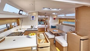 Un intérieur compact et bien éclairé, comprenant un coin cuisine, un espace repas et un petit coin salon.
