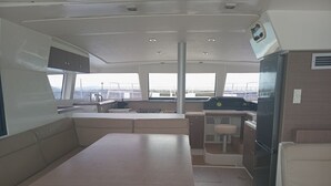 A boat interior with a dining area, kitchen, and seating. - Seychelles Sun-Soaked Sailing: A Pristine Beach Experience from Praslin (Baie Ste Anne)