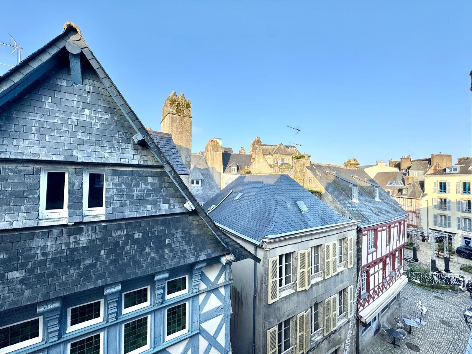 A traditional European town with historic buildings, including a prominent tower and a half-timbered house.