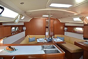 L’intérieur d’un bateau comprend un espace repas, une allée centrale et une cuisine équipée d’un évier.