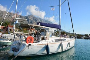 Un voilier baptisé « Oceans 37 » était amarré dans une marina, avec une chaîne de montagnes en toile de fond.