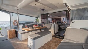 En lyxig inredning i en yacht med ett matområde, sittplatser och ett kök.
