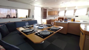 Een compacte keuken met een eethoek, met een tafel gedekt voor vier personen, een bank en een kleine kitchenette.
