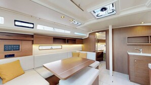 Un intérieur moderne comprenant un coin salon, une table, un coin cuisine et un plafond doté de lucarnes.