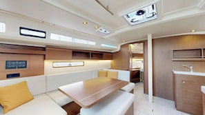 Un intérieur moderne comprenant un coin salon, une table, un coin cuisine et un plafond doté de lucarnes.