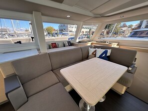 Un interior moderno con un sofá, una mesa y vistas al puerto deportivo.