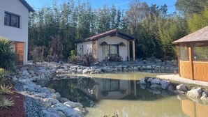 A house with a pond, a wooden deck, and a small building with a red roof. - DOMAINE COUL'EAU (Eaunes)