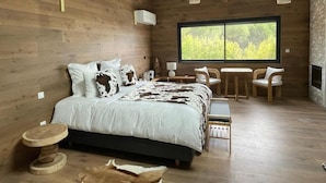 A wooden interior with a bed, a table, chairs, and a large window. - DOMAINE COUL'EAU (Eaunes)