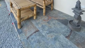 A patio with a wooden bench and table, a stone lantern, and a view of the outdoors. - DOMAINE COUL'EAU (Eaunes)