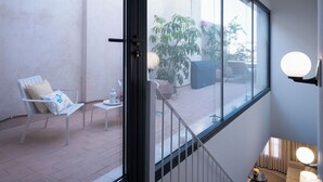 Moderni sisustus, jossa on suuri ikkuna, josta avautuu näkymä ulkotilalle, jossa on patio.