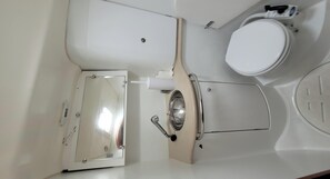 A bathroom with a toilet, a sink, and a mirror.