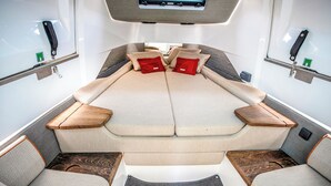 A boat interior with a central seating area, side tables, and a small control panel. - Sun-Kissed Sailing Adventure to the Serene Saronic Islands (Anavyssos)