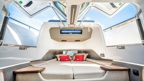 A luxurious RV interior with a central seating area, large windows, and a mounted entertainment system. - Sun-Kissed Sailing Adventure to the Serene Saronic Islands (Anavyssos)