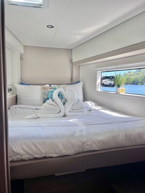 Una cama bien hecha con ropa blanca y una decoración de toallas.