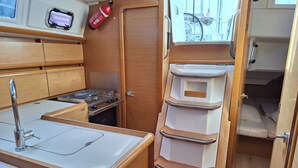 A compact kitchenette with a stove, sink, and storage cabinets.