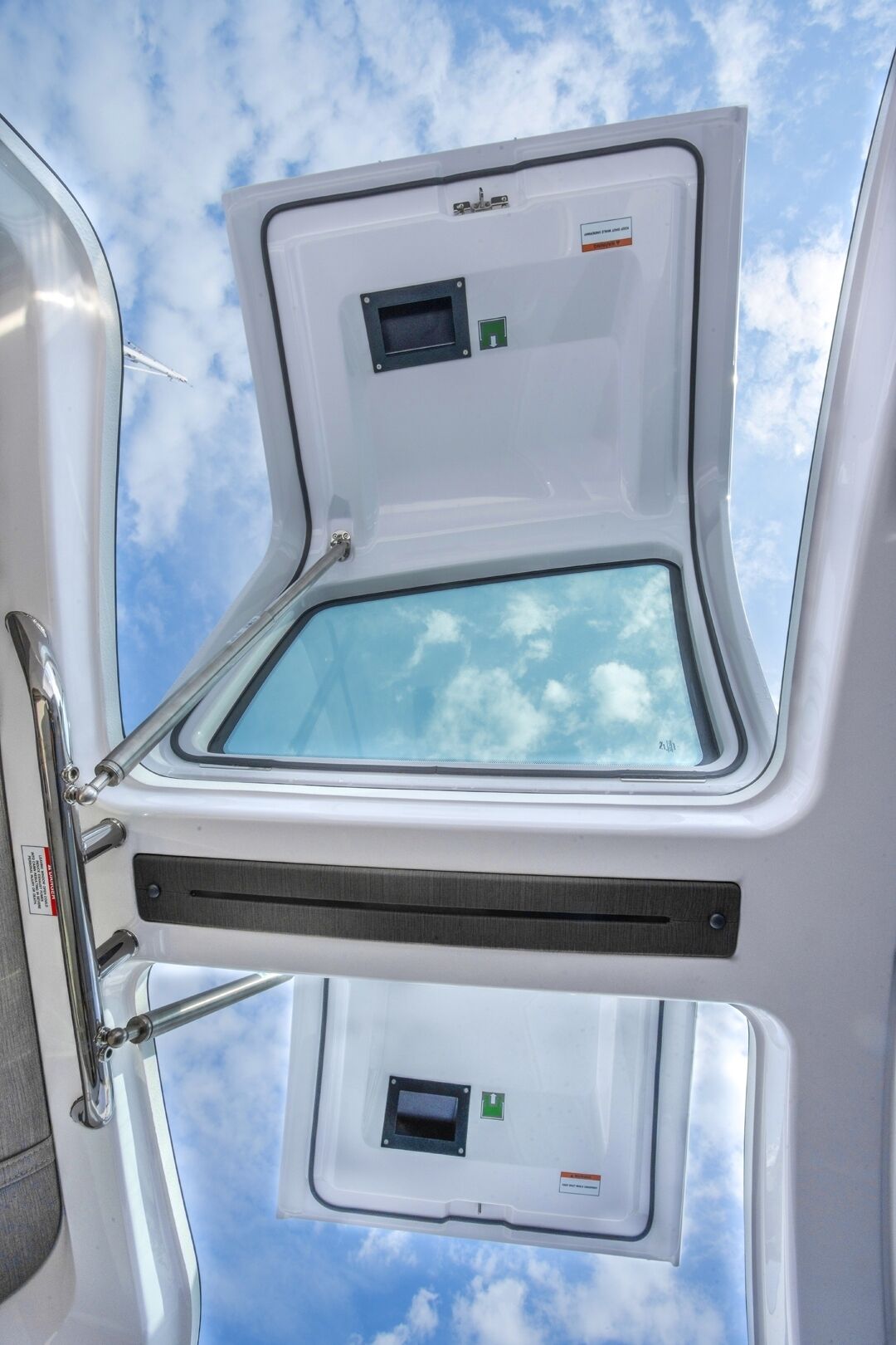Das Innere eines Wohnmobils mit Dachfenster, kleinem Fenster und einer Türgriff.