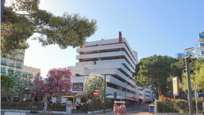 Un immeuble à plusieurs étages doté de balcons, d’une promenade piétonne et d’une rue où l’on peut circuler à vélo.