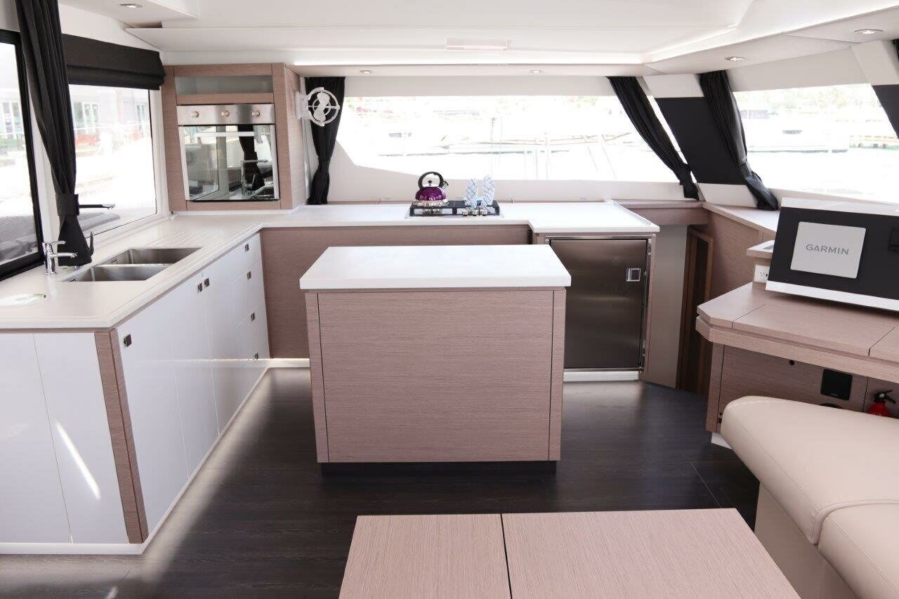 A compact kitchen with a central island, a built-in oven, and a small sink.