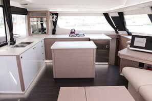 A compact kitchen with a central island, a built-in oven, and a small sink. - Caribbean Dream: Sun-soaked Sailing Adventure from Tortola, Islas Vírgenes Británicas (Road Town)
