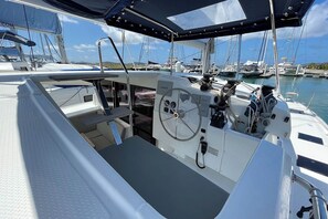 A boat's cockpit with a steering wheel, Garmin navigation equipment, and a covered seating area. - Caribbean Dream: Sun-soaked Sailing Adventure from Tortola, Islas Vírgenes Británicas (Road Town)