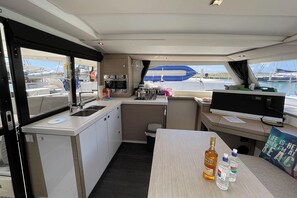 A compact galley with a sink, stove, and small refrigerator. - Caribbean Dream: Sun-soaked Sailing Adventure from Tortola, Islas Vírgenes Británicas (Road Town)