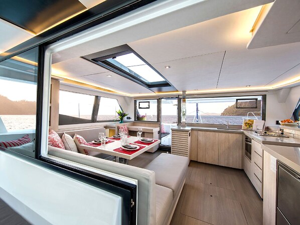 A modern interior with a dining area, seating, and a kitchen.
