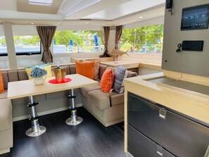 A modern interior with a sofa, table, and kitchen area. - Caribbean Dream: Sun-soaked Sailing Adventure from Tortola, Islas Vírgenes Británicas (Road Town)