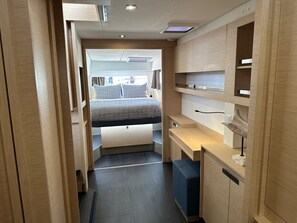 A compact, modern room with a bed, a desk, and built-in shelving. - Caribbean Dream: Sun-soaked Sailing Adventure from Tortola, Islas Vírgenes Británicas (Road Town)