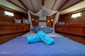 Ein Bett mit blauer Bettwäsche, einem Baldachin und zwei Nachttischen mit Körben.