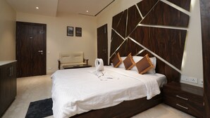 A bedroom with a bed, bedside tables, a wardrobe, and a headboard with a geometric design. - EENNRA GUEST HOUSE, Malda (Malda)
