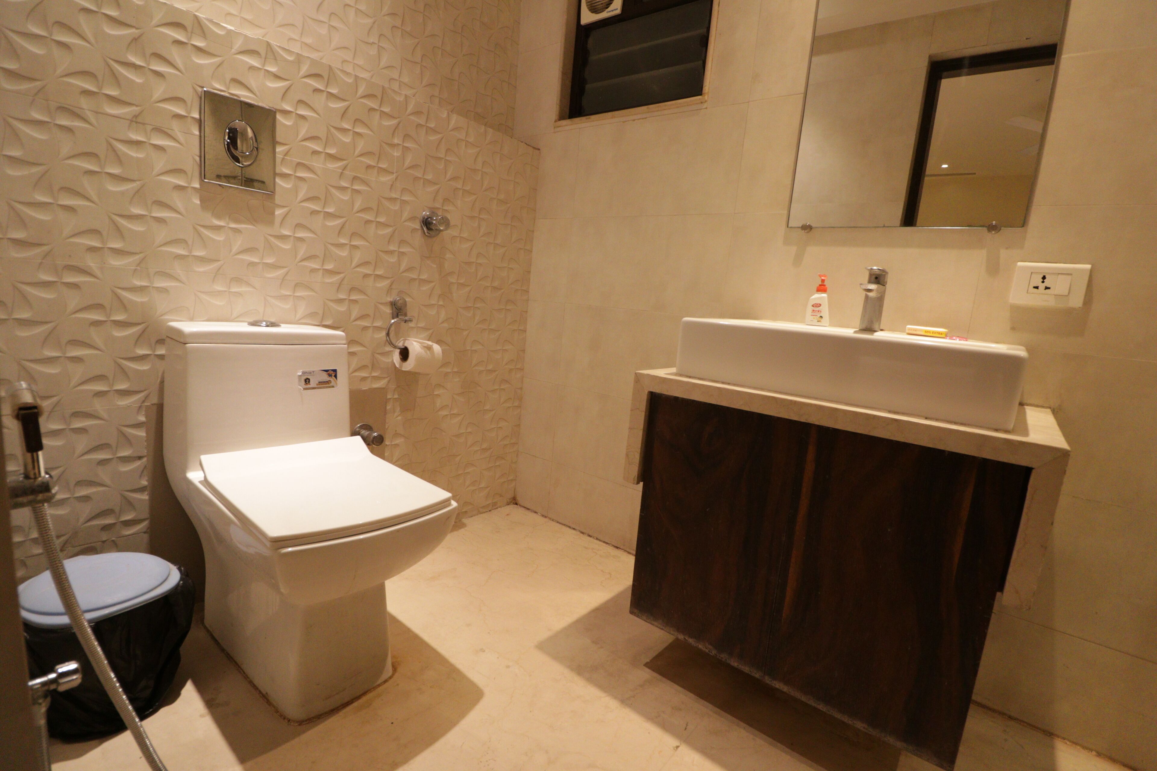 Ein Badezimmer mit Toilette, Waschbecken, Spiegel und Dusche.