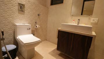 Ein Badezimmer mit Toilette, Waschbecken, Spiegel und Dusche.