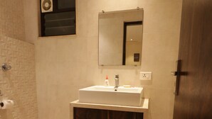 A bathroom with a toilet, a sink, a mirror, and a shower area. - EENNRA GUEST HOUSE, Malda (Malda)