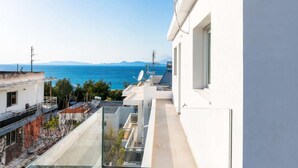 Ein moderner Balkon mit freiem Blick auf das Meer und ferne Berge.
