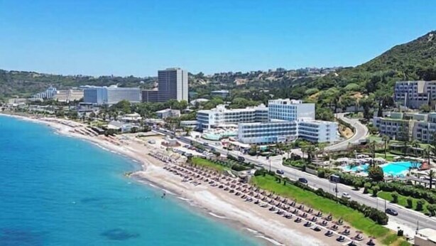 Eine Küstenstadt mit Strand, Hotelgebäuden und blauem Himmel.