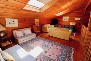 A cozy room with a wooden ceiling, a sofa, a patterned rug, and a television. - Charming villa with pool & idyllic terrace A3691 (Lège-Cap-Ferret)