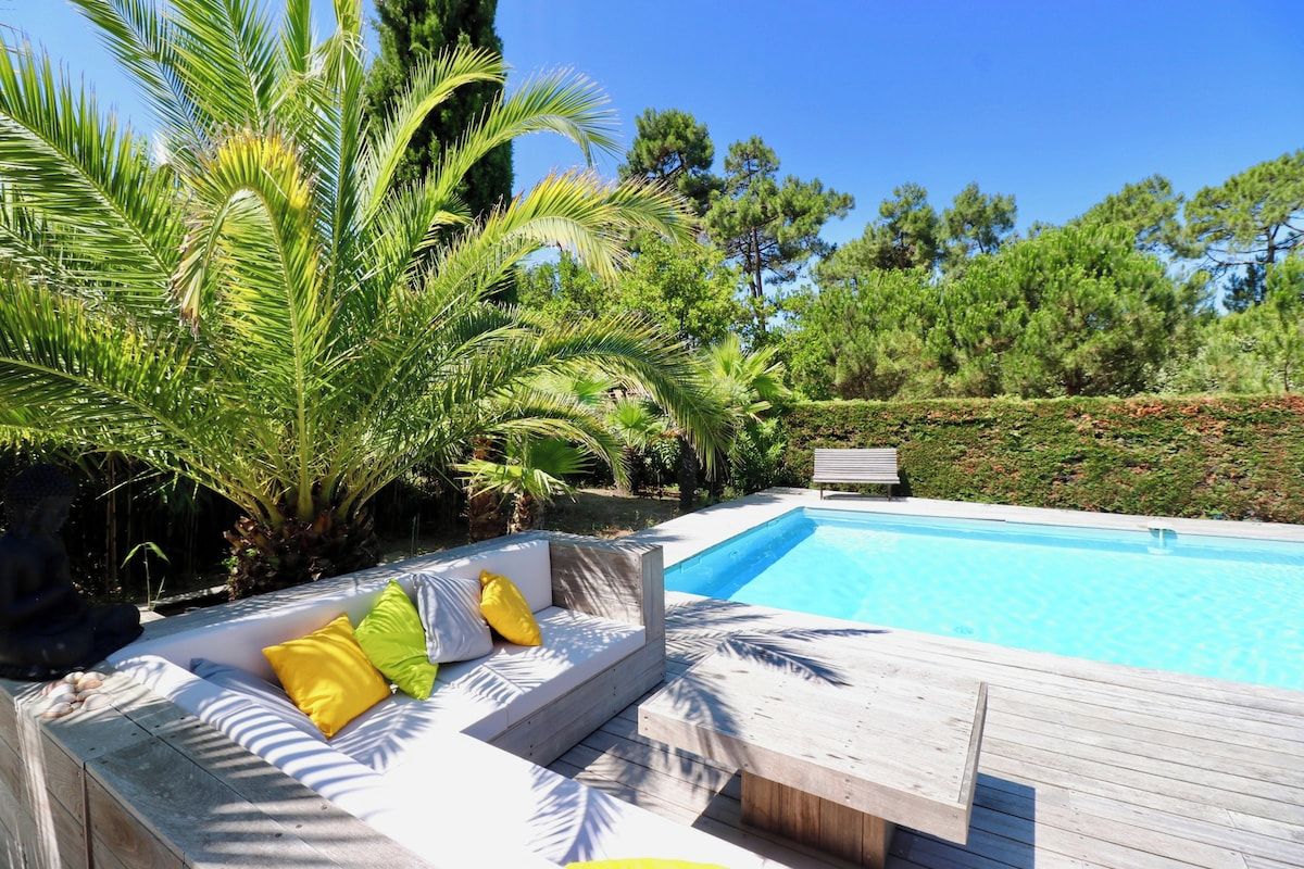 Une piscine dotée d’une terrasse en bois et d’un espace détente avec des sièges.