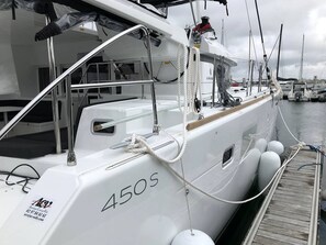 Un iot blanc amarrat a la marina, amb el número 450s visible al costat.