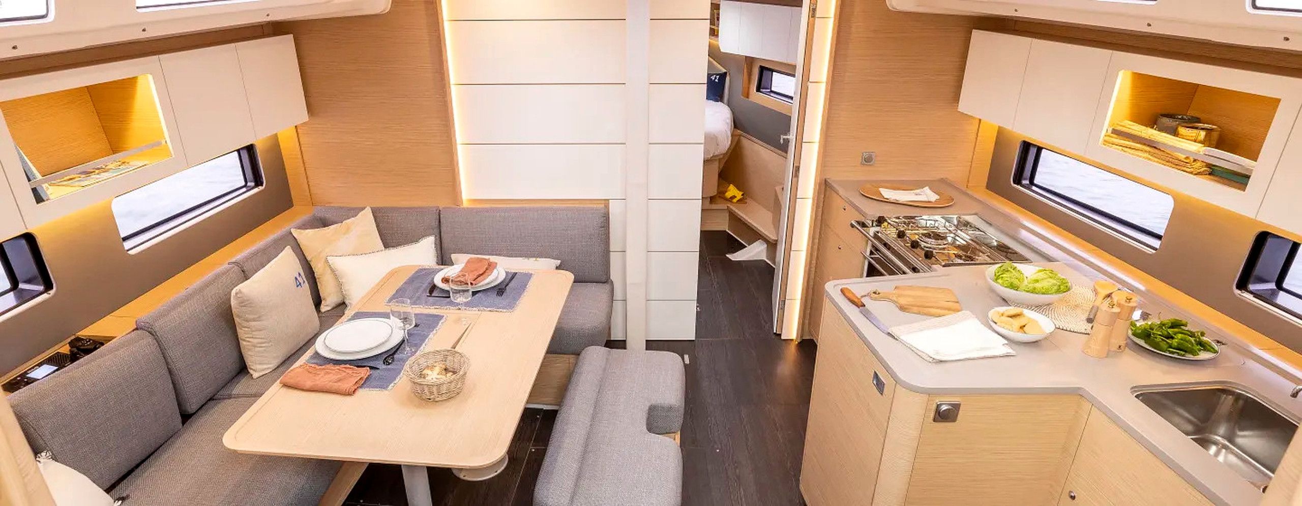 Un intérieur de camping-car compact comprenant un coin repas, une kitchenette et un espace nuit.